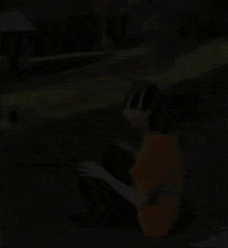 a man is sitting on the side of a road wearing a yellow shirt and a black hat .