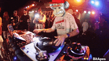 a man wearing a monkey mask is playing music on a turntable at a party