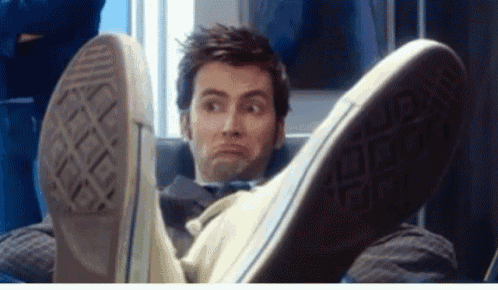 a man is laying down with his feet up and making a face