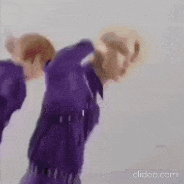 a couple of men are standing next to each other in purple shirts .