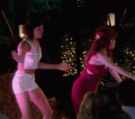 two women are dancing in front of a crowd at a party