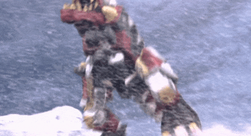 a robot is standing on top of a snow covered hill in the snow .