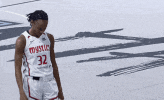 a female basketball player wearing a white jersey with the number 32 on it