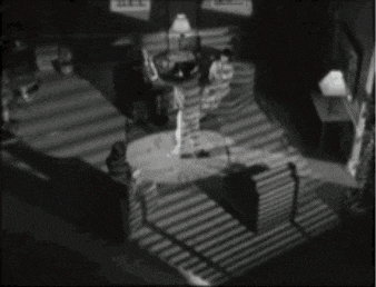 a black and white photo of a woman standing in a dark room