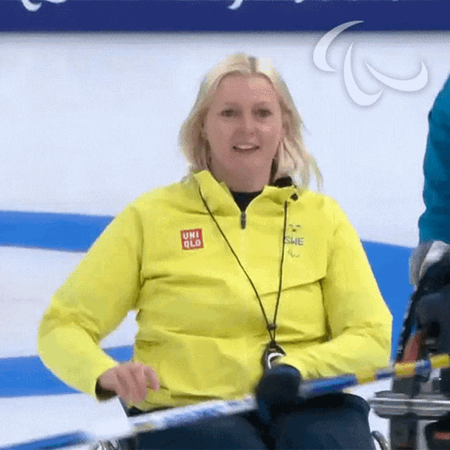 a woman wearing a yellow uniqlo jacket is smiling