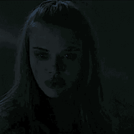 a close up of a woman 's face with glowing eyes in the dark .