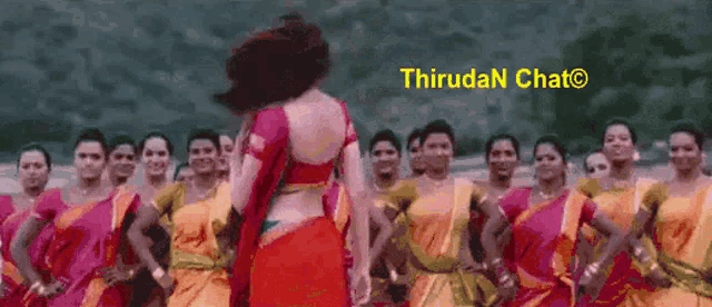 a woman in a red top is standing in front of a group of women in yellow and pink dresses ..
