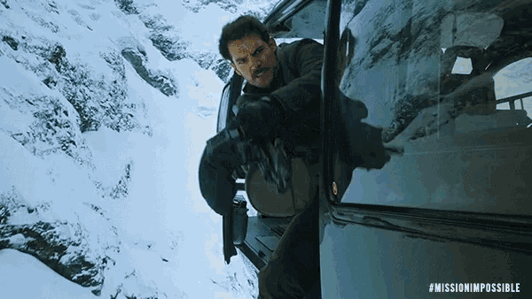 a man is getting out of a car in the snow with the hashtag missionimpossible