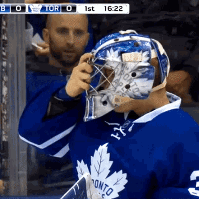 a hockey player wearing a helmet that says toronto