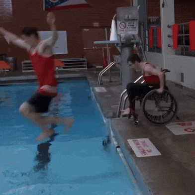 a person in a wheelchair dives into a pool