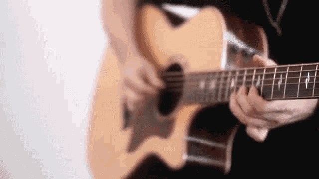 a person is playing an acoustic guitar in a blurry photo .