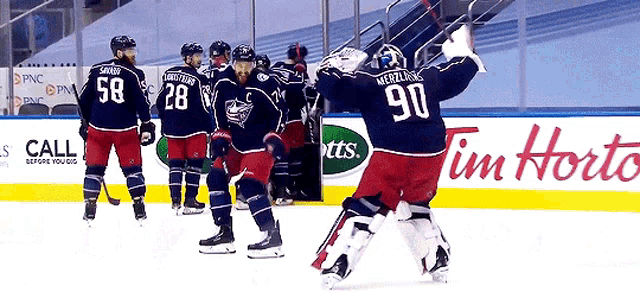 a hockey player with the number 90 on his jersey stands on the ice