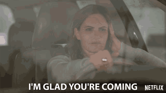 a woman in a car with the words i 'm glad you 're coming