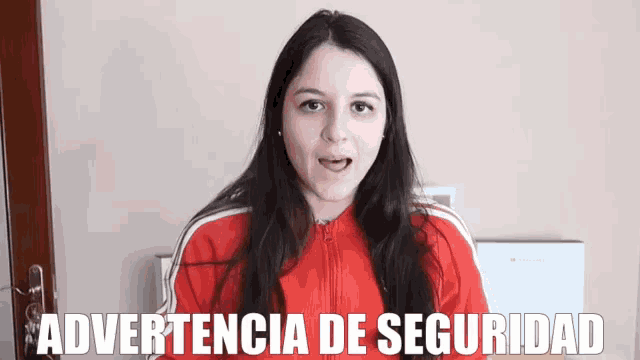 a woman wearing a red jacket with the word advertencia de seguridad on the bottom