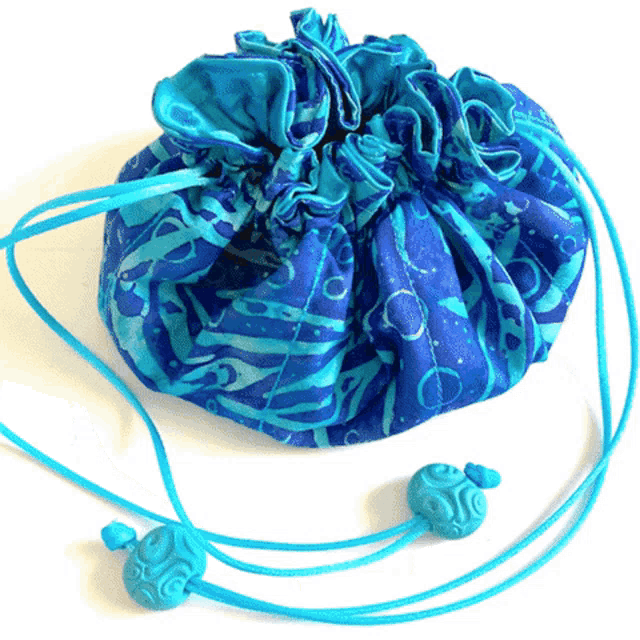 a blue drawstring bag with two blue beads on a white background