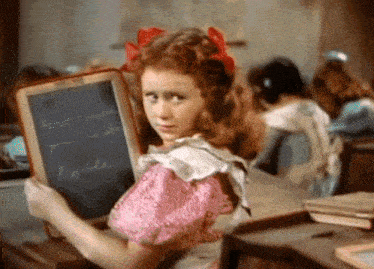 a girl in a pink dress is holding a chalkboard that says robbie on it
