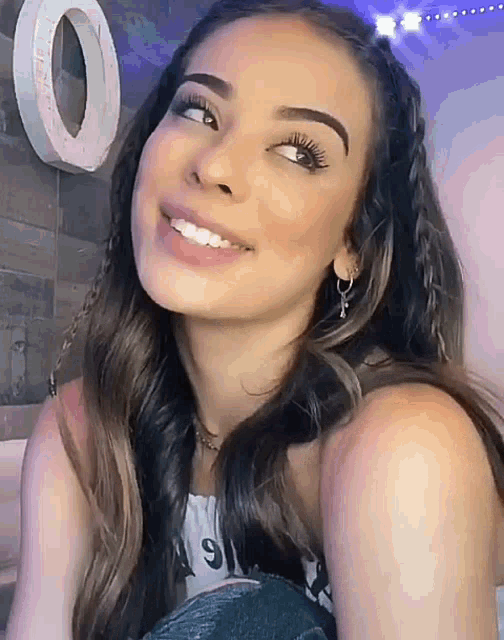 a woman is smiling and looking at the camera while wearing a braided headband .