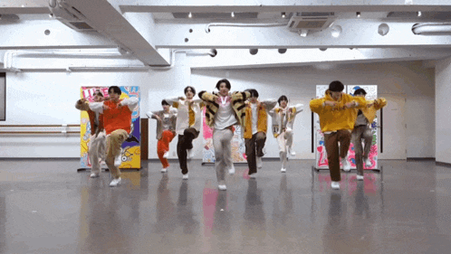 a group of young men are dancing together in a room