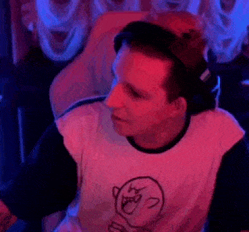 a man wearing headphones and a t-shirt with a drawing of a ghost on it is smiling .