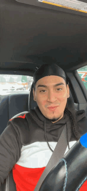 a man is sitting in the back seat of a car with a seat belt on