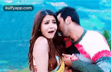 a man is kissing a woman on the cheek while a woman looks surprised .