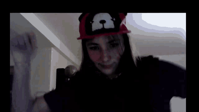 a girl is wearing a hat with a bear on it