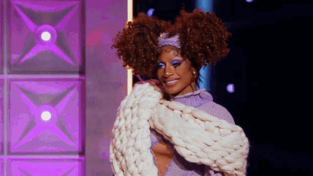 a woman with curly hair is wearing a white sweater and a headband