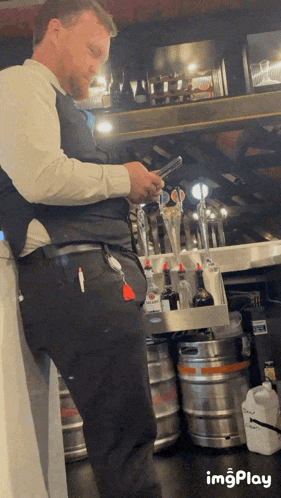 a man standing in front of a bar looking at a phone