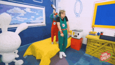 a cartoon character named gato galinha is standing next to a boy in overalls