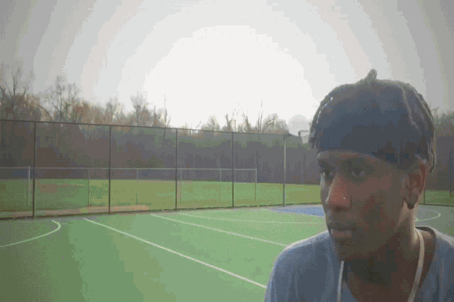 a young man wearing a headband stands on a tennis court