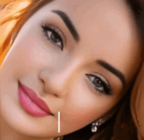 a close up of a woman 's face with a white line pointing to her cheek