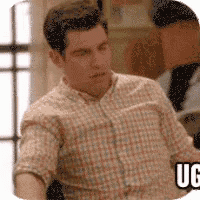 a man in a plaid shirt is sitting in front of a window and a sign that says uc .