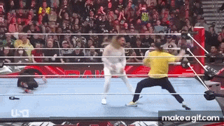 two men are wrestling in a wrestling ring with a crowd watching .