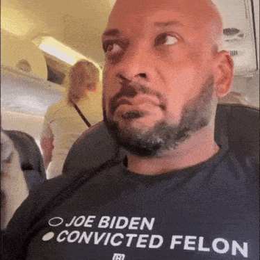 a man with a beard wears a shirt that says joe biden convicted felon