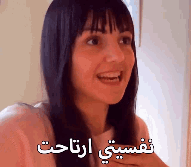 a woman in a pink shirt with arabic writing on it