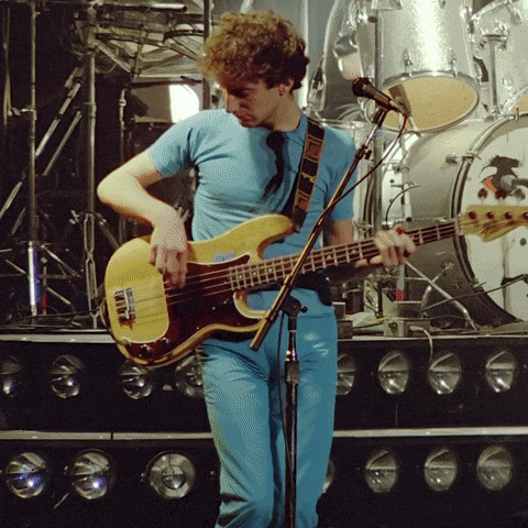 a man in a blue shirt is playing a guitar