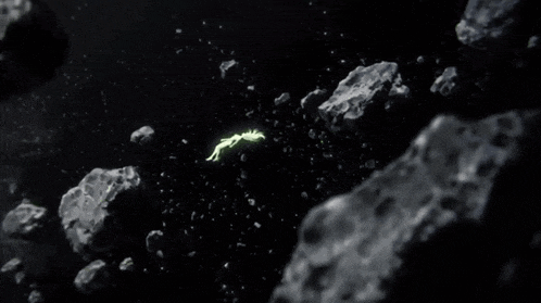 a person is floating in space surrounded by rocks and asteroids .