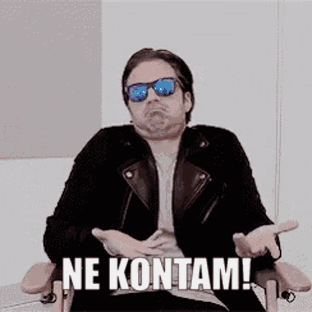 a man wearing sunglasses and a leather jacket is sitting in a chair with the words ne kontam written on it