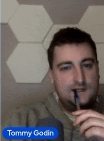 a man with a pen in his mouth and the name tommy godin below him