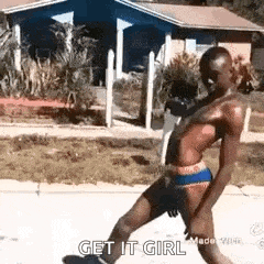 a shirtless man in underwear is walking down a street .