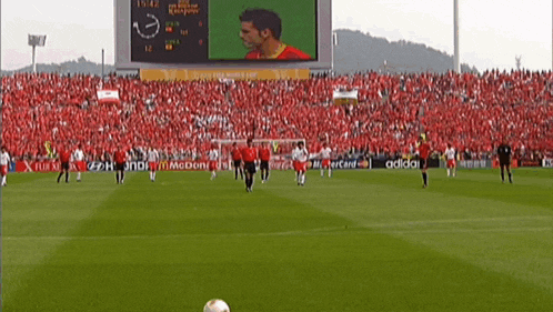 a soccer game is being played in front of a large crowd with ads for adidas and mcdonald 's