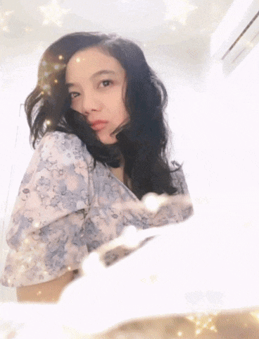 a woman in a floral shirt is taking a picture of herself