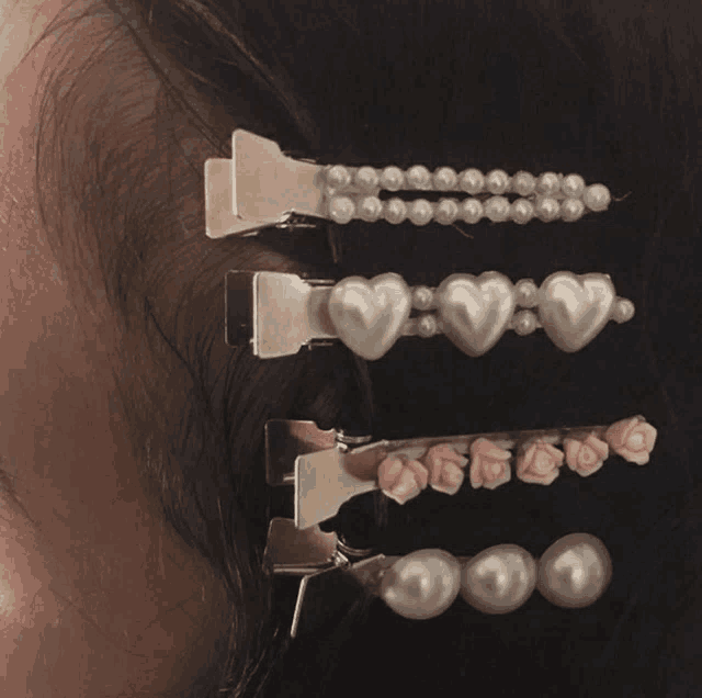 a close up of a woman 's hair clips with pearls and roses
