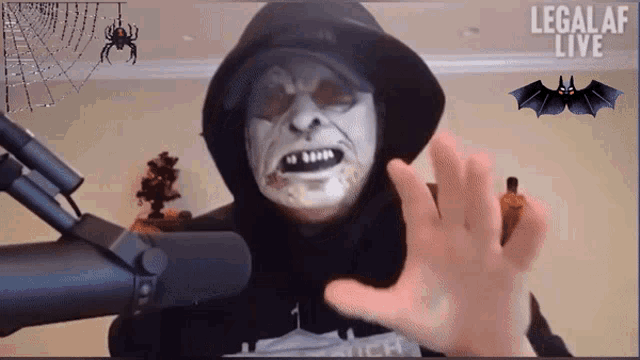 a man in a hooded mask is talking into a microphone and the words legalaf live are on the bottom