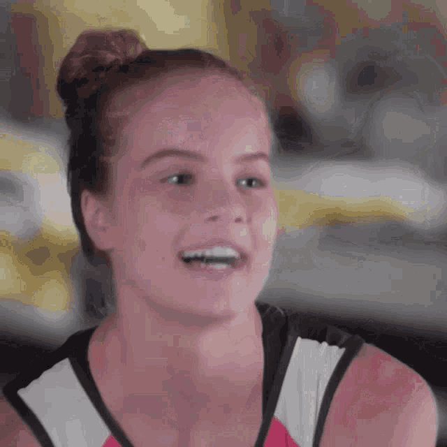 a woman with her hair in a bun is smiling for the camera