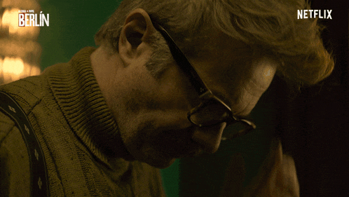 a man wearing glasses and a sweater with the word berlin on it