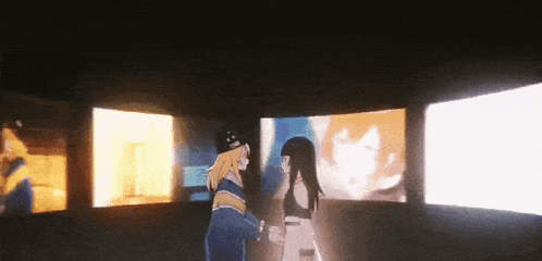 a couple of anime characters are standing next to each other in front of a screen .