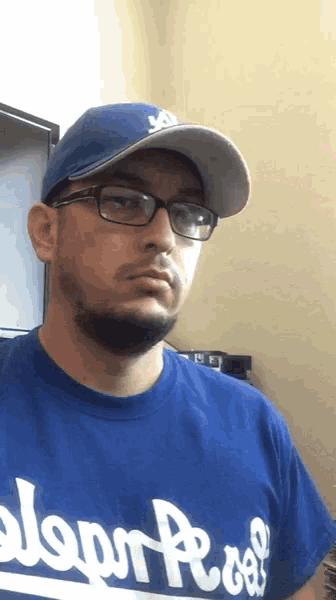 a man wearing a hat and glasses is wearing a blue shirt that says ' clean roof ' on it