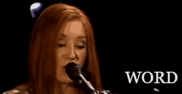 a woman singing into a microphone with the word word in the corner