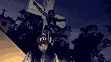 a person wearing a hat that says ftp is standing in front of a cross